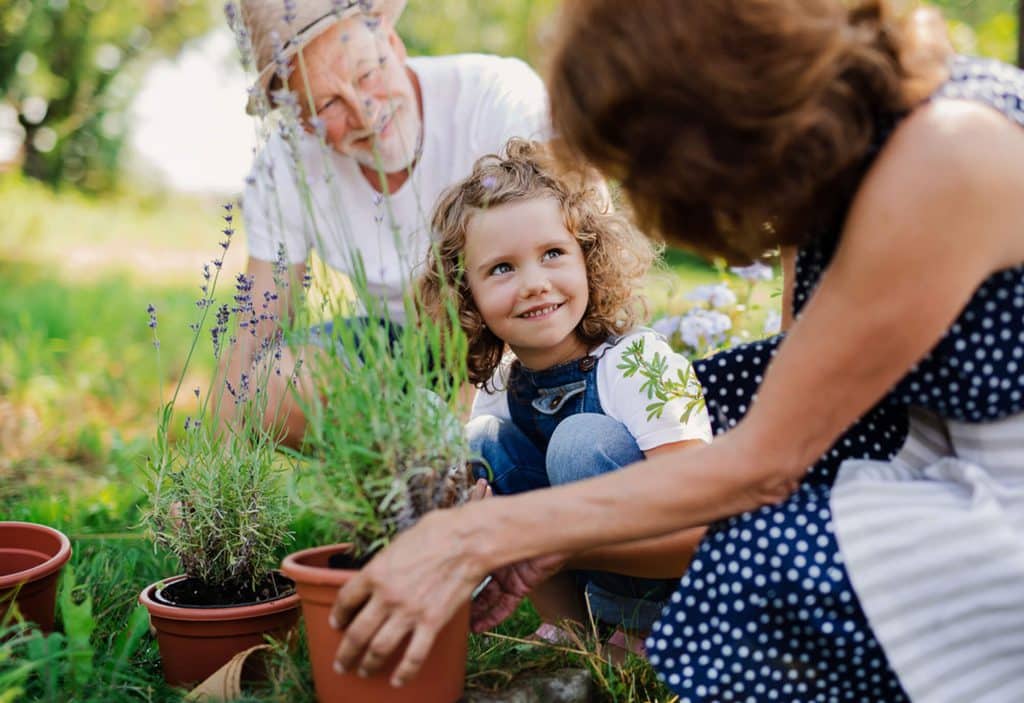 a man, woman and child planting plants in pots at Meridian Homes indianapolis rentals